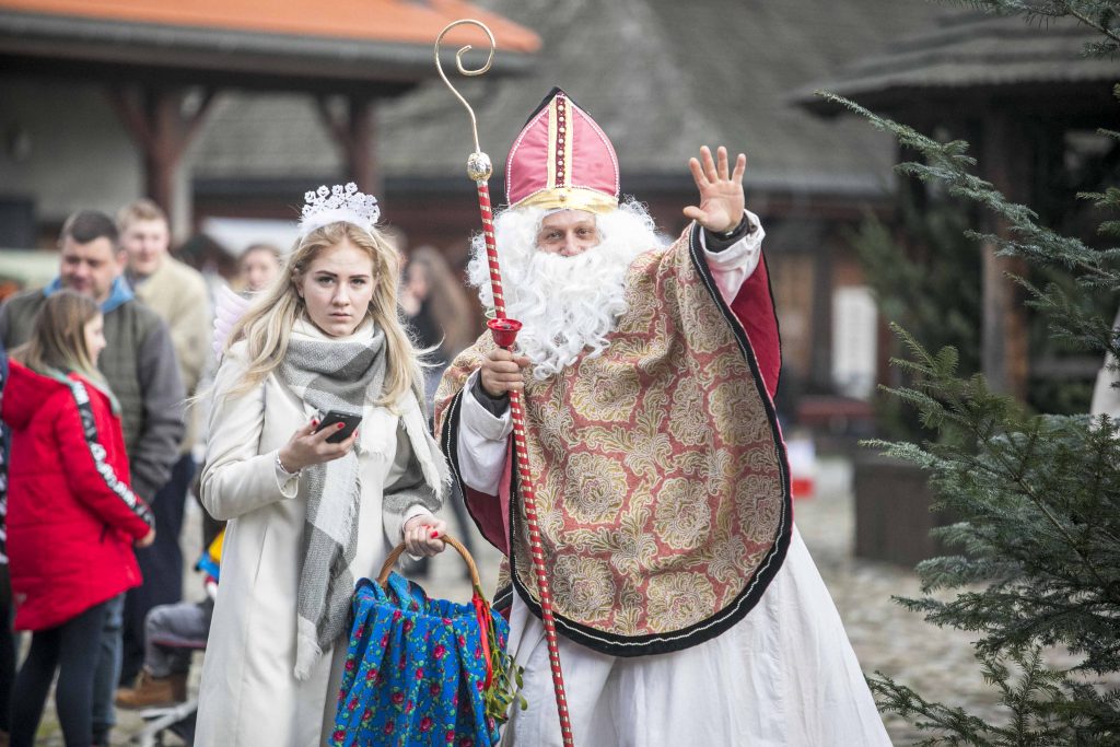 Kobieta przebrana za anioła i mężczyzna przebrany za świętego Mikołaja pozują do zdjęcia na rynku Miasteczka Galicyjskiego podczas Bożonarodzeniowego Jarmarku. 