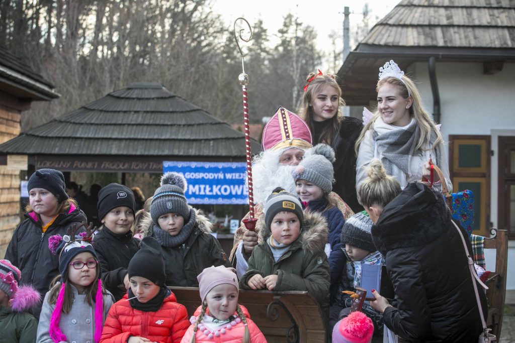 Grupa dzieci pozuje do zdjęcia na tle świętego Mikołaja w Miasteczku Galicyjskim podczas Bożonarodzeniowego Jarmarku. 