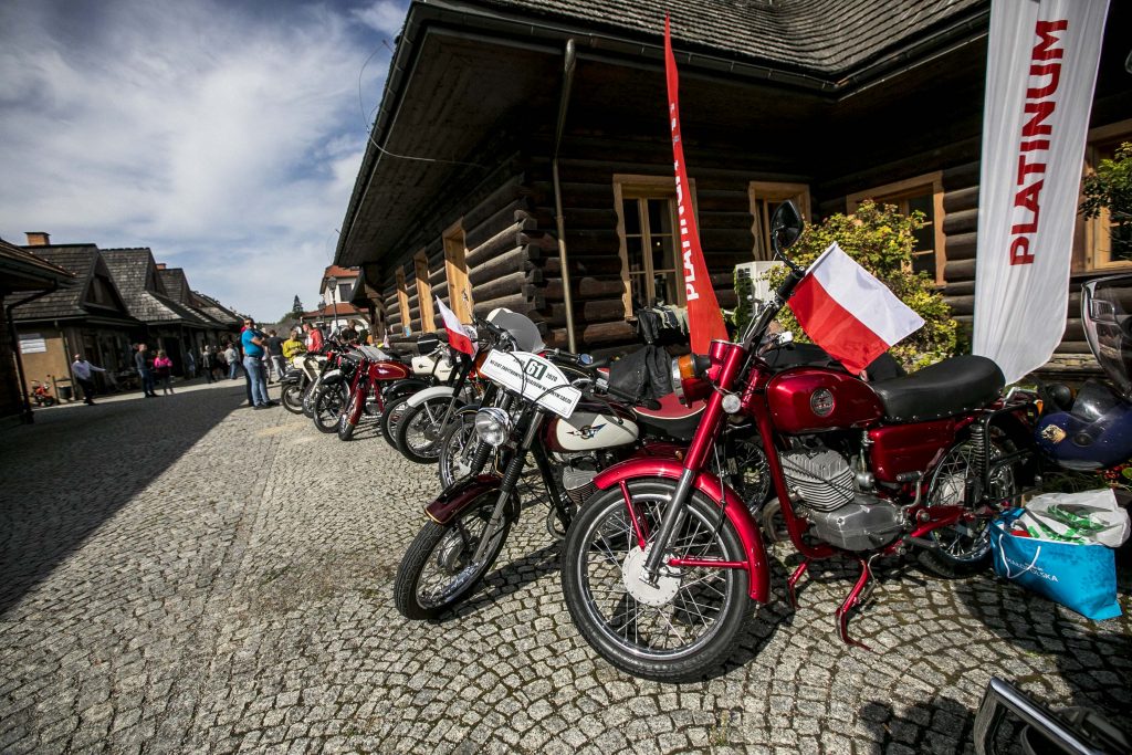 Na alejce, która prowadzi do rynku Miasteczka Galicyjskiego, stoi rząd zabytkowych motorów.. Przy motorach kręcą się ludzie i oglądają zabytkowe pojazdy. 